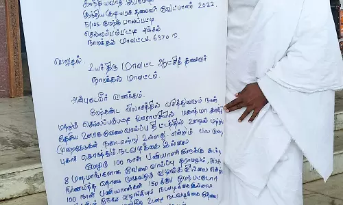 நாமக்கல் கலெக்டர் அலுவலகத்துக்கு  பிளக்ஸ் பேனரில் கோரிக்கையை எழுதி வந்தவரால் பரபரப்பு