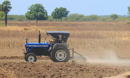 விளை நிலத்தை உழவு செய்யும் பணியில் விவசாயிகள்