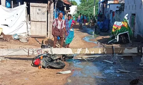 மின்கம்பம் பெயர்ந்து விழுந்து இருசக்கர வாகனம் சேதம்