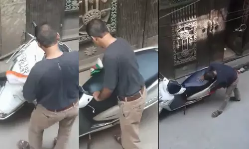 தேசியக்கோடியை பைக் துடைக்கும் துணியாக பயன்படுத்திய நபர்