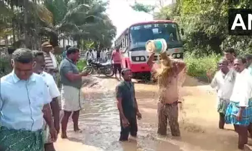 கர்நாடகாவில் சாலைகளில் தேங்கிய வெள்ள நீரில் குளித்து மக்கள் நூதன போராட்டம்