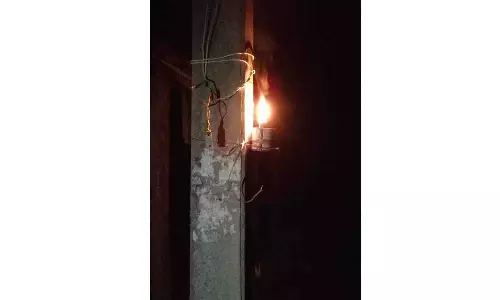 மின் கம்பத்தில் மண்எண்ணெய் விளக்கு வைத்த வாலிபர்கள்