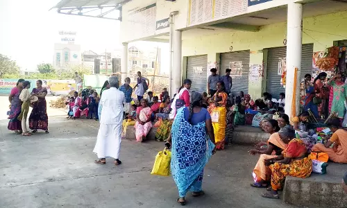 போதிய இருக்கைகள் இல்லாததால் தரையில் அமரும் பயணிகள்