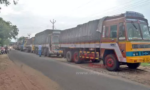 லாரிகளில் இருந்து மதுபாட்டில்களை இறக்க மறுத்து தொழிலாளர்கள் போராட்டம்