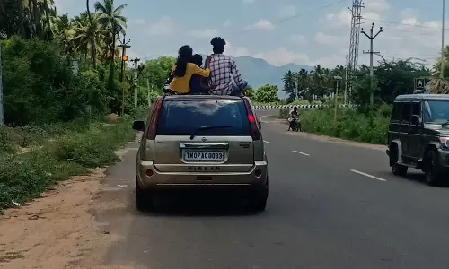 கம்பம்-கூடலூர் சாலையில் காரின் மேற்கூரையில் அமர்ந்தபடி ஆபத்தான பயணம்