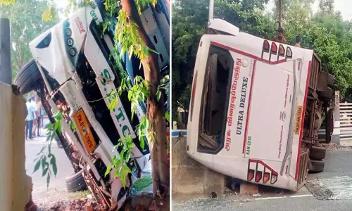 பள்ளிக்கூட சுற்றுச்சுவரில் மோதியதில் பஸ் கவிழ்ந்தது