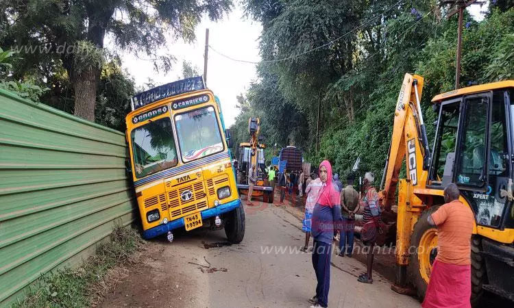 கோத்தகிரியில் மரத்துண்டுகளை ஏற்றி வந்த போது மண்ணில் சக்கரங்கள் புதைந்து லாரி சரிந்தது-முதியோர் இல்லத்தில் மரத்துண்டுகள் உருண்டு விழுந்ததால் பரபரப்பு