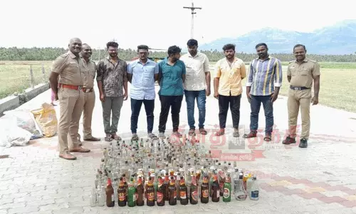 விவசாய நிலத்தில் கிடந்த காலி மதுபாட்டில்களை அகற்றிய போலீசார்