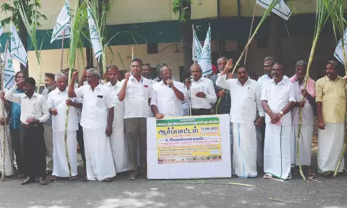 மடத்துக்குளம் அமராவதி கூட்டுறவு சர்க்கரை ஆலை முன் கையில் கரும்புடன் விவசாயிகள் போராட்டத்தில் ஈடுபட்டனர்.