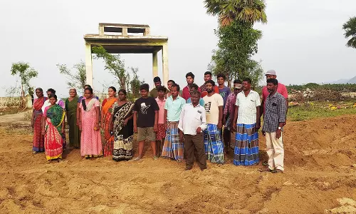 சுடுகாட்டில் நின்று கிராம மக்கள் போராட்டம்