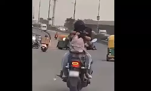 பெட்ரோல் டேங்க் மீது அமர்ந்து வாலிபரை கட்டிப்பிடித்தவாறு பைக்கில் சென்ற இளம்பெண் - ரூ.11 ஆயிரம் அபராதம் விதித்த போலீசார்