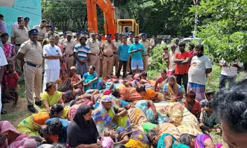 பொக்லைன் எந்திரத்தை முற்றுகையிட்டு தரையில் படுத்து பெண்கள் போராட்டம்