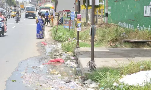 நிழற்குடை முன் பாயும் கழிவுநீரால் பயணிகள் அவதி நிழற்குடை முன் பாயும் கழிவுநீரால் பயணிகள் அவதி