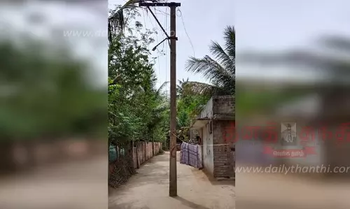 சாலையின் நடுவே மின்கம்பம்