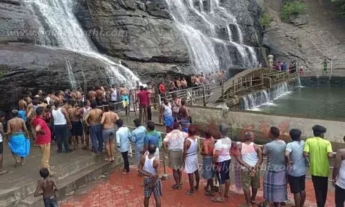 குற்றாலம் அருவிகளில் வரிசையில் நின்று குளித்த சுற்றுலா பயணிகள்