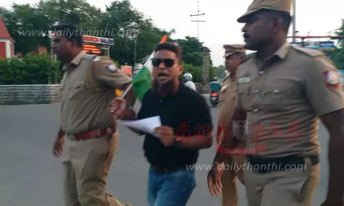 தேசிய கொடியுடன் வாலிபர் திடீர் போராட்டம்