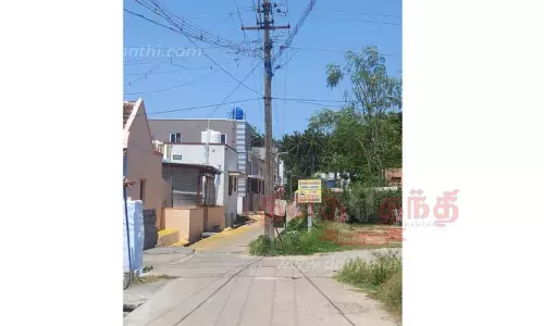 சாலையின் நடுவில் மின்கம்பம்