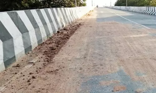 சாலையில் சிதறிகிடக்கும் ஜல்லி கற்கள், மணல்