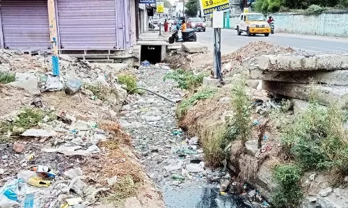 கழிவுநீர் கால்வாயில் குவிந்து கிடக்கும் குப்பைகள்