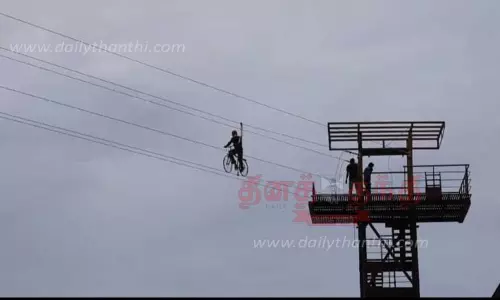 பெரியகுளத்தின் கரைகளுக்கு இடையேகம்பி மேல் சாகச சைக்கிள் சவாரி