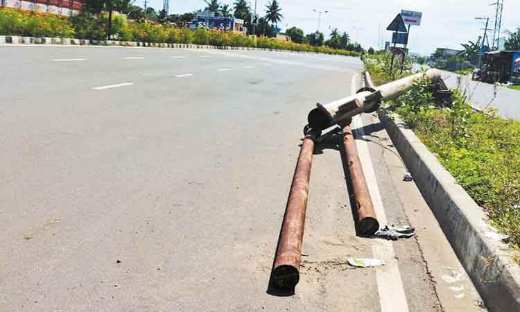 சிங்கப்பெருமாள் கோவில் அருகே சாலையில் விழுந்து கிடக்கும் வழிகாட்டி பெயர்ப்பலகை