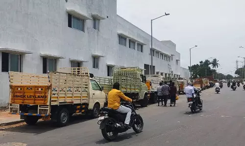 சாலையை ஆக்கிரமித்து நிறுத்தப்படும் சரக்கு வேன்கள்