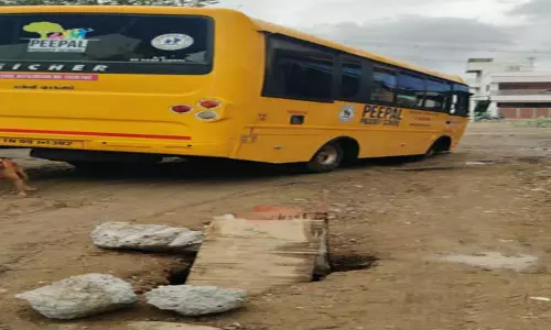 குனியமுத்தூரில் சாலையோர பள்ளத்தில் சிக்கிய தனியார் பள்ளி பஸ்