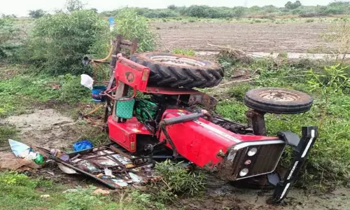 ஓட்டப்பிடாரம் அருகே பள்ளிக்கூட வேன் உரசியதால் சாலையோர பள்ளத்தில் டிராக்டர் கவிழ்ந்து பெண் உள்பட 2 பேர் உடல் நசுங்கி பரிதாபமாக இறந்தனர்.