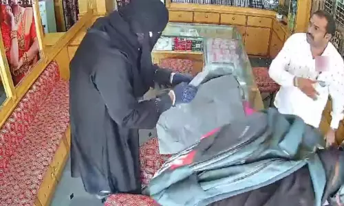 பர்தா அணிந்து நகைக்கடைக்குள் நுழைந்த திருடன்: கத்தி முனையில் மிரட்டி தங்க நகைகள் கொள்ளை - அதிர்ச்சி வீடியோ