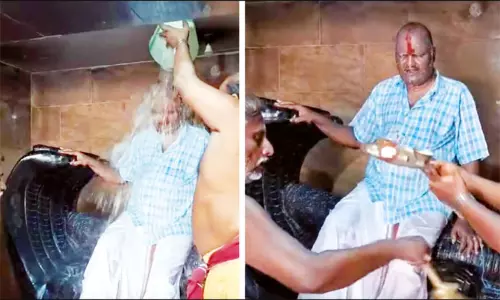 பெருமாள் சிலை மீது உட்கார்ந்த சாமியாருக்கு அபிஷேகம், தீபாராதனை