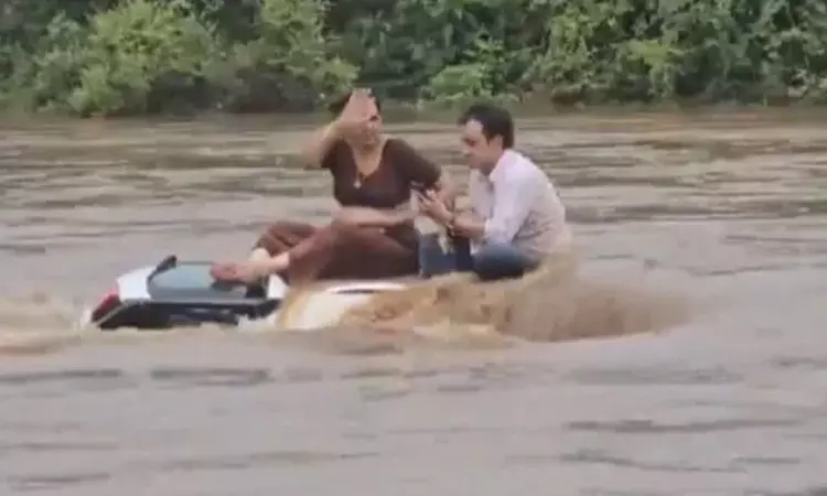 ஆற்றில் திடீர் வெள்ளம்: காரின் மேலே அமர்ந்து உயிர் தப்பிய தம்பதி - வைரல் வீடியோ