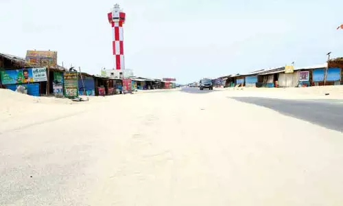 பலத்த சூறாவளி காற்று: தனுஷ்கோடியில் சாலையை மூடிய மணல்