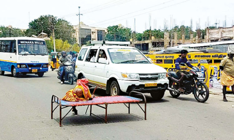 வயதான தாயை கட்டிலுடன் சாலையின் நடுவே அமர வைத்த நபர்; தேனியில் பரபரப்பு