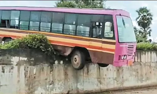 மீஞ்சூர் அருகே சாலையோர பள்ளத்தில் தொங்கிய அரசு பஸ்