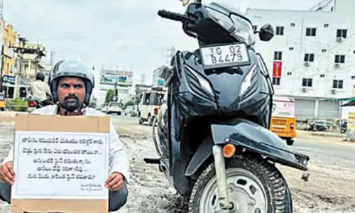 சேதமடைந்த சாலையை சீரமைக்க கோரி சமூக ஆர்வலர் நூதன போராட்டம்